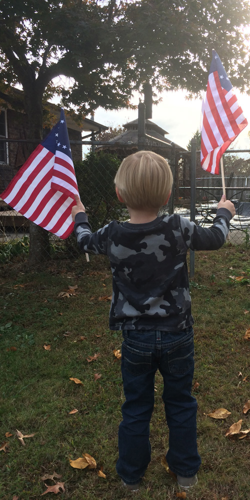 Child waving American flags