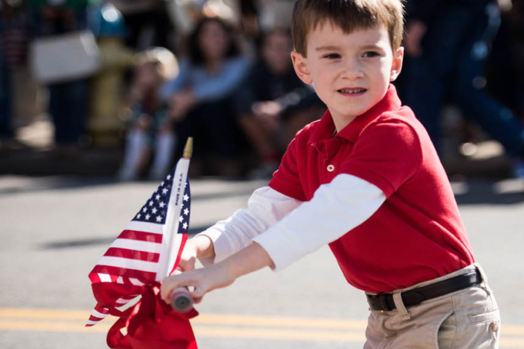 boy on scooter in parade